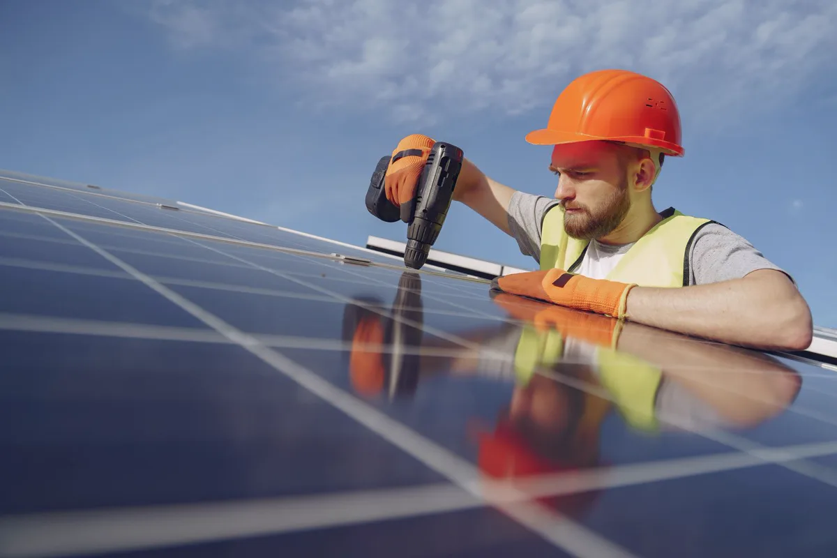 Solar Service Technician inspecting solar panels on a roof in Multan